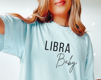 May include: A light blue t-shirt with the text "LIBRA Baby" in black lettering.