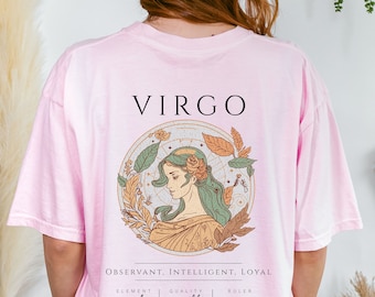 May include: Pink t-shirt with a Virgo zodiac sign graphic. The graphic features a woman with long green hair, surrounded by leaves and flowers. The text "VIRGO" is at the top of the graphic, and the text "OBSERVANT, INTELLIGENT, LOYAL" is below the graphic. The text "ELEMENT earth QUALITY mutable RULER mercury AUGUST 23 - SEPTEMBER 22" is at the bottom of the graphic.