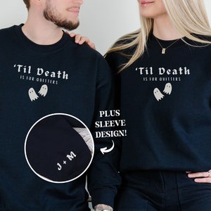 Op de afbeelding: Zwart longsleeve sweatshirt met de tekst 'Til Death is for quitters' en een spookgrafiek. Het sweatshirt heeft een bijpassend mouwontwerp met de tekst 'J+M'.