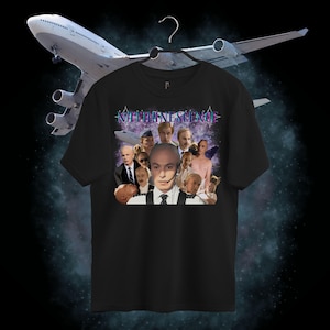 Pode incluir: Camiseta preta com uma colagem de imagens e a palavra "NATHANESCENCE" em uma fonte estilizada. O design inclui um retrato de um homem com fone de ouvido e outras figuras. Um grande avião está no fundo.