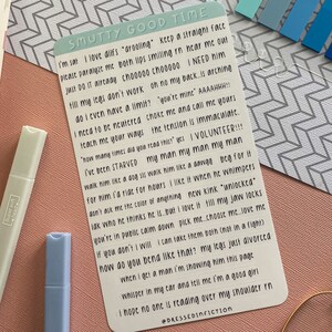 May include: A white card with black text on it. The text reads "SMUTTY GOOD TIME" and includes a list of phrases about love, relationships, and dating. The phrases are written in a playful and humorous tone.