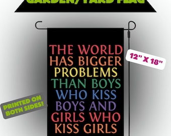 May include: Black garden flag with the text "THE WORLD HAS BIGGER PROBLEMS THAN BOYS WHO KISS BOYS AND GIRLS WHO KISS GIRLS" in rainbow colors. The flag measures 12" x 18" and is printed on both sides.
