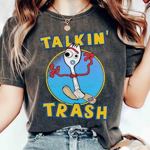 May include: Dark grey t-shirt with a cartoon image of Forky from Toy Story, and the words "TALKIN' TRASH" in yellow block letters. The Forky character is inside a blue circle.
