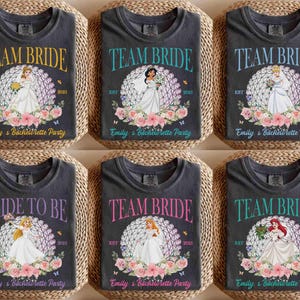 K&ouml;nnte beinhalten: Sechs dunkelgraue T-Shirts mit Braut-Designs. Jedes Shirt zeigt eine Prinzessinnen-Illustration, die Worte "Team Bride" oder "Bride to Be" und "Emily's Bachelorette Party". Blumen- und Schmetterlingsakzente umgeben die Prinzessinnen-Bilder.