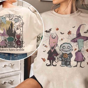 Puede incluir: Sudadera beige con un gr&aacute;fico de "Pesadilla antes de Navidad". El dise&ntilde;o incluye personajes como Jack Skellington y Sally, con murci&eacute;lagos, telara&ntilde;as y caramelos. El texto "The Nightmare Before Christmas" tambi&eacute;n es visible.