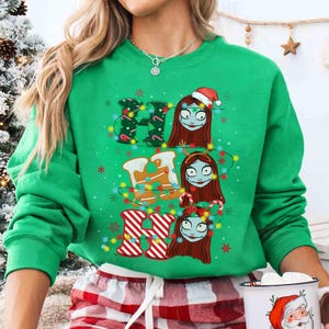 May include: A green sweatshirt with the word "HO HO HO" spelled out with Christmas-themed designs. The "H" is decorated with Christmas lights and holly, the "O" with gingerbread men, and the last "O" with candy canes and striped stockings. The design features a character with red hair and stitches.