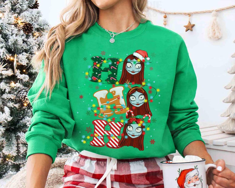 May include: A green sweatshirt with the word "HO HO HO" spelled out with Christmas-themed designs. The "H" is decorated with Christmas lights and holly, the "O" with gingerbread men, and the last "O" with candy canes and striped stockings. The design features a character with red hair and stitches.