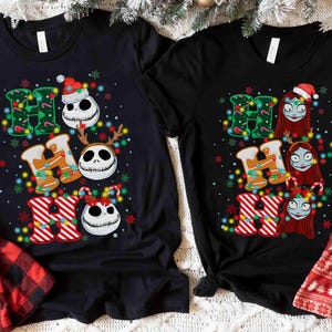 May include: Two black t-shirts with a festive Christmas design. One shirt features Jack Skellington and the other Sally from The Nightmare Before Christmas, with the words "HO HO HO" in a colorful, holiday-themed font.