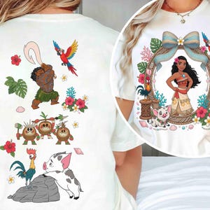 May include: A cream-colored t-shirt featuring a graphic print of Moana characters. The back displays Maui, Kakamora, a rooster, and a piglet with tropical flowers. The front circular design shows Moana framed by a bow, flowers, and a parrot.