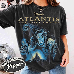 Könnte beinhalten: Ein anthrazitfarbenes Kurzarm-T-Shirt mit einem Grafikdruck aus Disneys Atlantis: Das Geheimnis der verlorenen Stadt. Das Design zeigt den Filmtitel in goldener Schrift über einer blau getönten Illustration der Hauptfiguren.