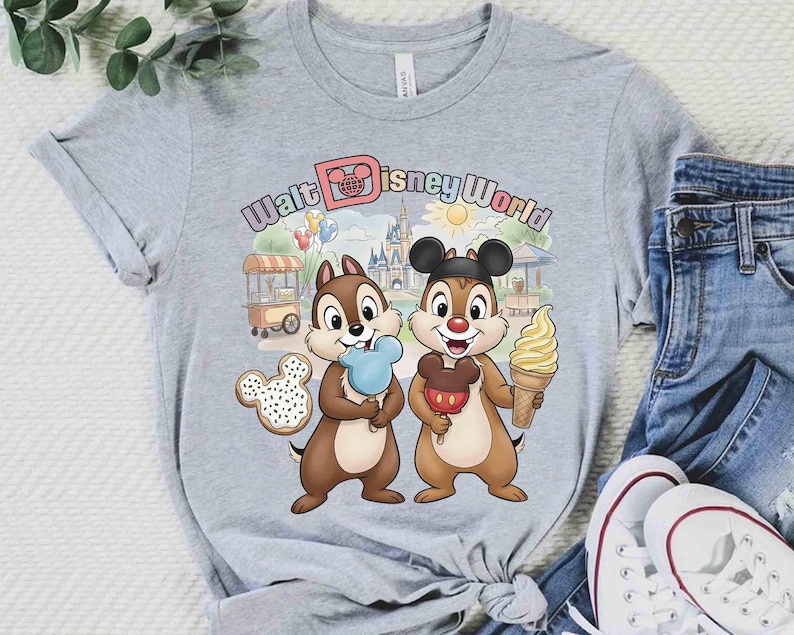 May include: A gray t-shirt featuring Chip and Dale with ice cream and a Mickey Mouse-shaped cookie, with the text "Walt Disney World" in a colorful font. The design includes a castle, sun, and food cart.