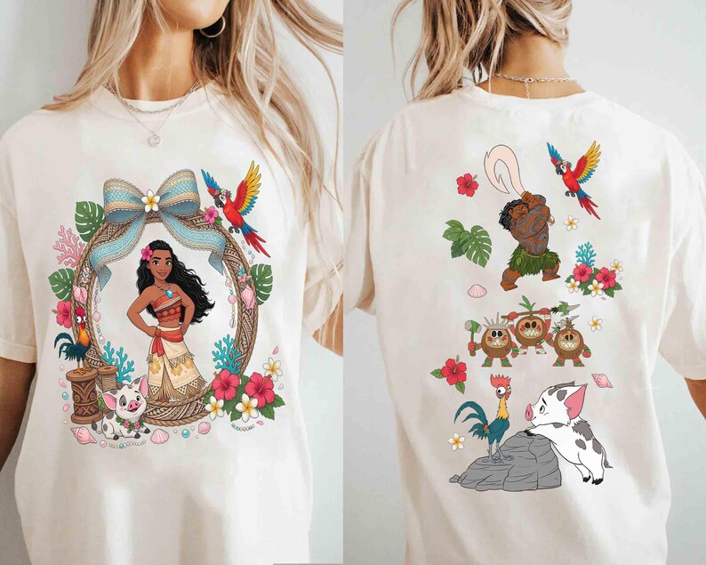 May include: A cream-colored t-shirt featuring a front graphic of a character in a patterned frame with a pig, a rooster, and a blue bow, and a back graphic showing a male character with a hook, three small coconut creatures, a rooster, and a pig.