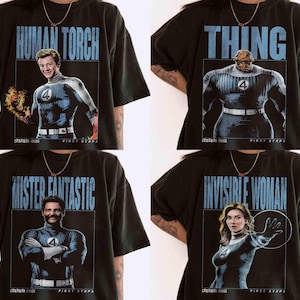 Può includere: Magliette nere con i personaggi dei Fantastici Quattro: Human Torch, Thing, Mister Fantastic e Invisible Woman. Ogni maglietta mostra l'immagine di un personaggio all'interno di un riquadro blu, con il nome del personaggio in testo blu. Il logo Marvel è visibile.