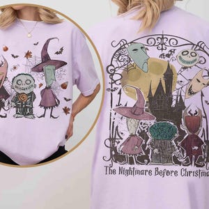 Puede incluir: Camiseta lila claro con personajes de "Pesadilla antes de Navidad". El dise&ntilde;o frontal muestra tres personajes con murci&eacute;lagos y telara&ntilde;as. El dise&ntilde;o trasero incluye un castillo, m&aacute;scaras y el texto "The Nightmare Before Christmas."