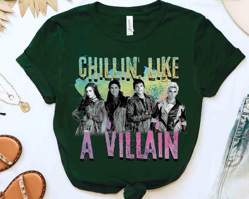 May include: Dark green t-shirt featuring a graphic of four people and the text "CHILLIN LIKE A VILLAIN" in colorful letters. The shirt is made of a soft material and has short sleeves.