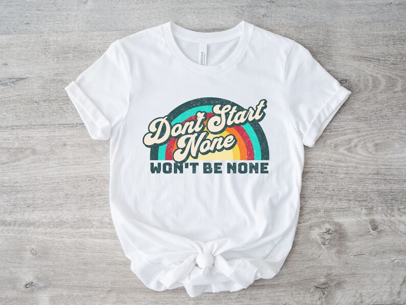 May include: White t-shirt with a retro rainbow graphic and the text "Don't Start None Won't Be None".