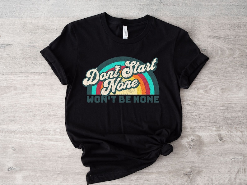 May include: Black t-shirt with a rainbow graphic and the text "Don't Start None Won't Be None".