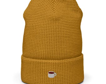 May include: A mustard yellow beanie with a small embroidered coffee cup design.