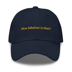 May include: A navy blue baseball cap with the text "How fabulous is that?" embroidered in yellow.
