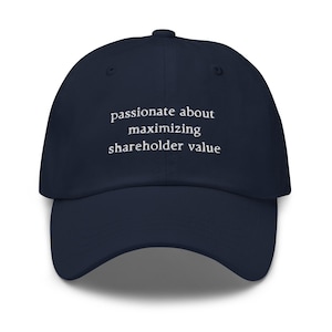 Peut inclure: Une casquette de baseball bleu marine avec un texte brodé en blanc qui dit "Passionné par la maximisation de la valeur pour les actionnaires".