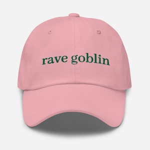 May include: A pink baseball cap with the text "rave goblin" embroidered in green.