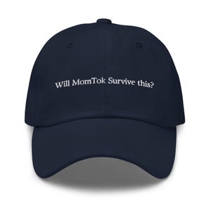 May include: A navy blue baseball cap with white embroidered text that reads "Will MomTok Survive this?"