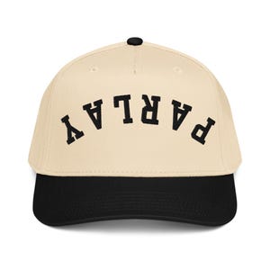 Könnte beinhalten: Baseballcap mit cremefarbener Krone und schwarzem Schirm. Das Wort "PARLAY" ist in Schwarz auf der Vorderseite aufgestickt. Die Kappe hat einen schwarzen Knopf oben.
