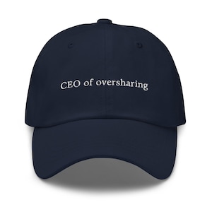 May include: A navy blue baseball cap with white embroidered text that reads "CEO of oversharing".