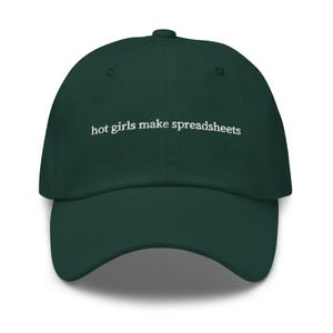 May include: A dark green baseball cap with the phrase "hot girls make spreadsheets" embroidered in white. The cap has a curved brim and a button on top. A casual accessory.