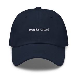 May include: A navy blue baseball cap with the text "works cited" embroidered in white on the front.