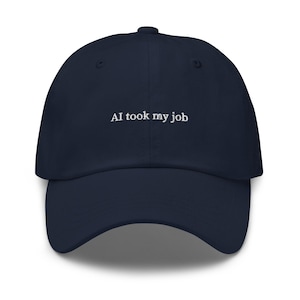 May include: A navy blue baseball cap with the white text "AI took my job" embroidered on the front. The cap has a curved brim and a button on top. This hat is a humorous statement piece.
