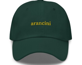Puede incluir: Una gorra de béisbol verde oscuro con la palabra "arancini" bordada en amarillo en la parte delantera.