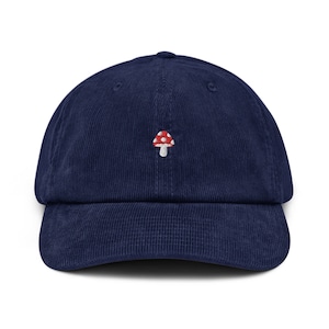 May include: A navy blue corduroy baseball cap with a white embroidered mushroom with red spots.