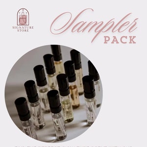 May include: A close-up of a set of small glass perfume bottles with black caps. The bottles are arranged in a circle on a white background. The text "Sampler Pack" is written in cursive above the bottles. The text "Signature Store" is written in a smaller font below the bottles.