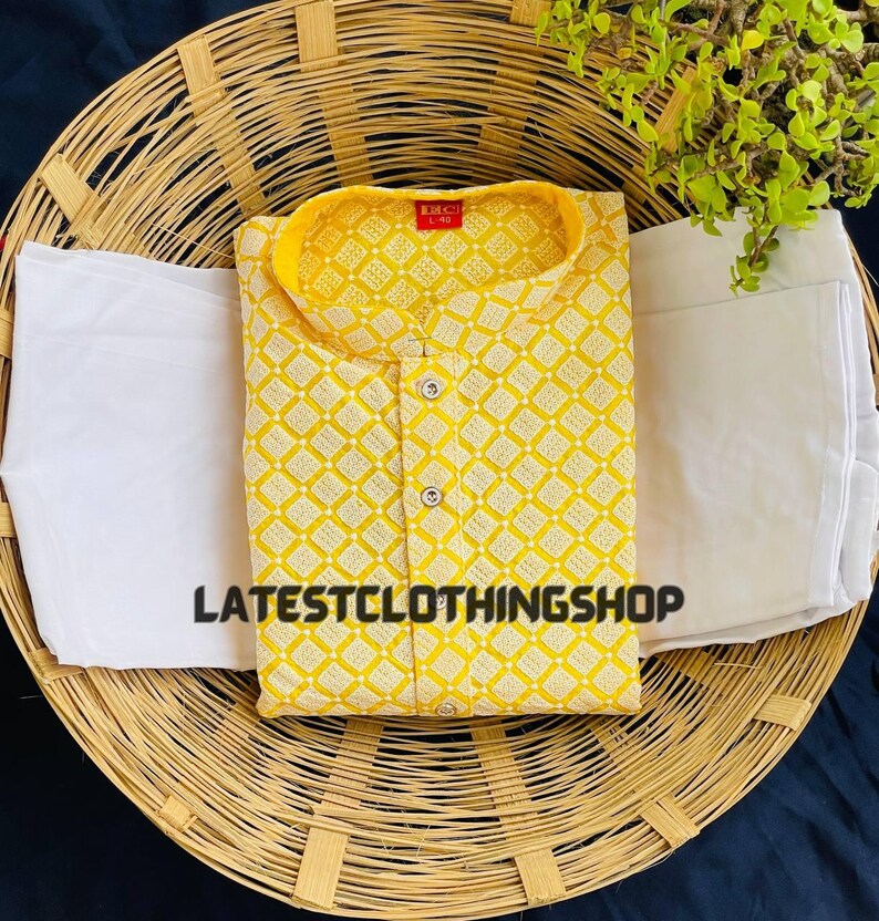 May include: A yellow kurta with a white geometric pattern and a white button-up collar. The kurta is on a woven basket with a white fabric underneath. The text "LATESTCLOTHINGSHOP" is visible on the fabric.