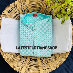May include: A light blue kurta with a white geometric pattern. The kurta has a mandarin collar and a button closure. The kurta is paired with a white bottom.