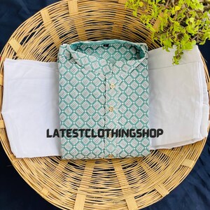 May include: A teal blue kurta with a white geometric pattern and a white bottom. The kurta is laid out on a woven basket.