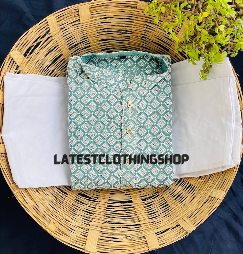 May include: A teal blue kurta with a white geometric pattern and a white bottom. The kurta is laid out on a woven basket.