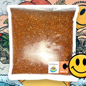 May include: A clear plastic bag filled with red sorghum grain. The bag has a label that reads "Red Sorghum".
