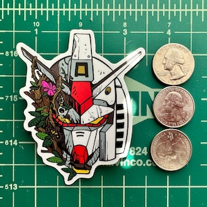May include: A white, red, and black sticker of a robot head with a green, brown, and yellow vine growing around it. The robot head has a red visor and a white face.