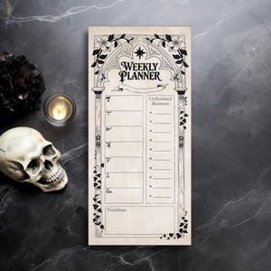 May include: A cream-colored weekly planner with black gothic-style floral and architectural design elements. The planner features the words "WEEKLY PLANNER" at the top and has spaces for each day of the week and "Unfinished Business" notes.