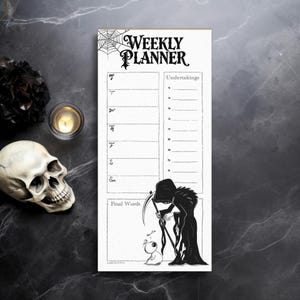 May include: A black and white weekly planner with a spooky theme. The top features a spiderweb and the words "Weekly Planner." The bottom has a Grim Reaper illustration with a small creature. The planner includes sections for each day and "Undertakings."