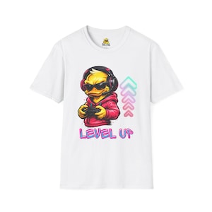 Puede incluir: Camiseta blanca con un pato de dibujos animados con auriculares y gafas de sol, sosteniendo un mando de videojuegos. El pato lleva una sudadera con capucha roja. Las palabras "LEVEL UP" están impresas en color debajo.