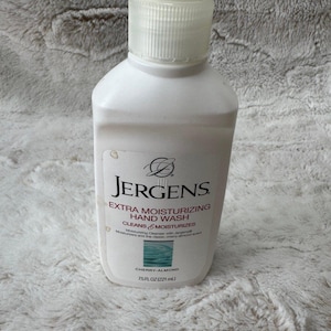 May include: A white plastic bottle of Jergens Extra Moisturizing Hand Wash with a clear pump dispenser. The label features the brand name, product description, and the text Cherry-Almond 7.5 fl oz (221 mL) with a small blue water graphic.