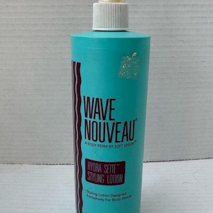 May include: A teal-colored bottle of Wave Nouveau Hydra Sette Styling Lotion. The bottle has a white spray nozzle and a label with the product name and description. The bottle contains 16 fl oz (473 ml) of styling lotion.