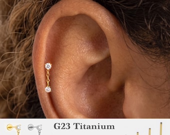 Könnte beinhalten: Ein goldfarbener Labret-Stecker mit einer zarten Kette, die zwei kleine, klare, runde Steine verbindet. Der Text G23 Titanium, 16g, 18g, 20g sowie 5mm, 6mm, 8mm, 10mm ist neben verschiedenen Stablängen und silberfarbenen Optionen zu sehen.