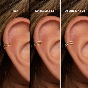 May include: Close-up of three gold-colored ear cuffs, each with a different design. The first cuff is plain, the second has a single line of small clear stones, and the third has a double line of clear stones. The text "Plain", "Single Line Cz", and "Double Line Cz" are above each cuff.
