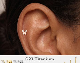 May include: A gold-toned butterfly-shaped stud earring with clear stones, featuring a flat back post. Text displays G23 Titanium, 16g, 18g, 20g, and 5mm, 6mm, 8mm, 10mm, alongside images of gold and silver butterfly studs and four post lengths.