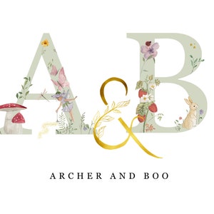 May include: A watercolor illustration of the letters A and B with floral and nature-themed designs. The letter A features a fairy, a mushroom, and a dragonfly. The letter B features a rabbit and strawberries. The text "ARCHER AND BOO" is written below the letters.