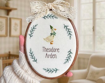 Baby name sign embroidered with storybook goose and greenery, newborn birth announcement plaque, oval nursery wall hanging, gift for new mum
